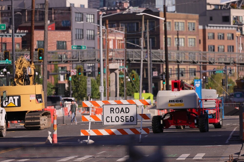 Road closed sign with construction equipment on Seattle street - active construction site